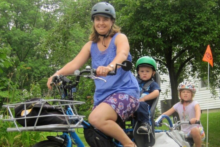 A woman and her kids commuting together via bike.