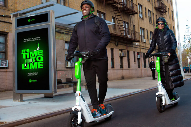 Two happy men on Lime scooters.