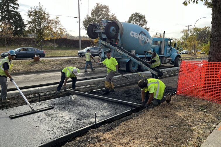 Cement truck and construction workers pouring a new bike lane