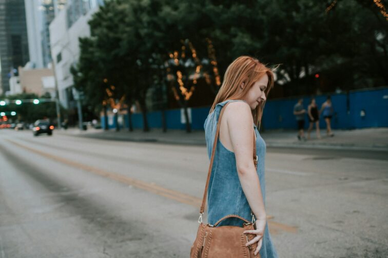 Woman crossing the street during daytime.